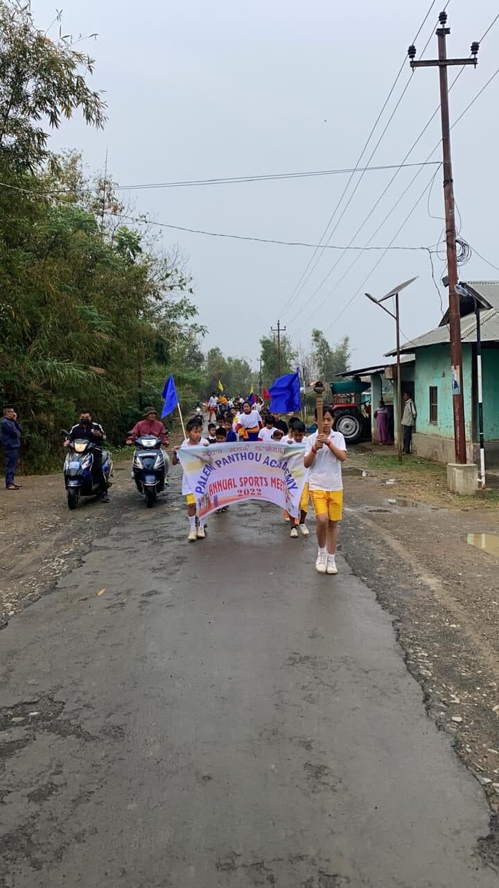 The school sports rally moving through the village road with banners